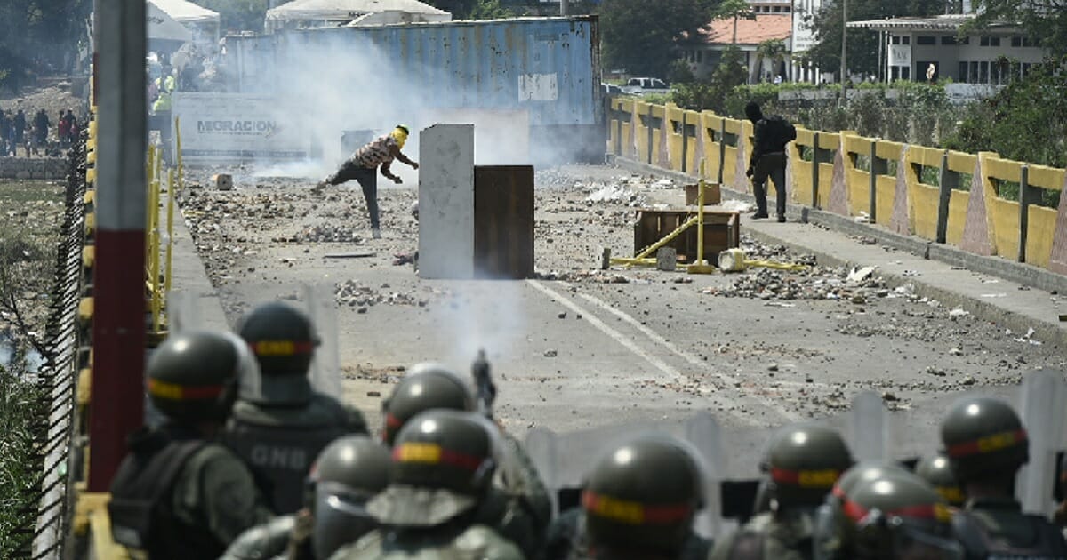 Demonstrators clash with Venezuelan military forces Sunday at the Venezuelan-Colombian border, where Venezuela's military is blocking international aid from entering the country.