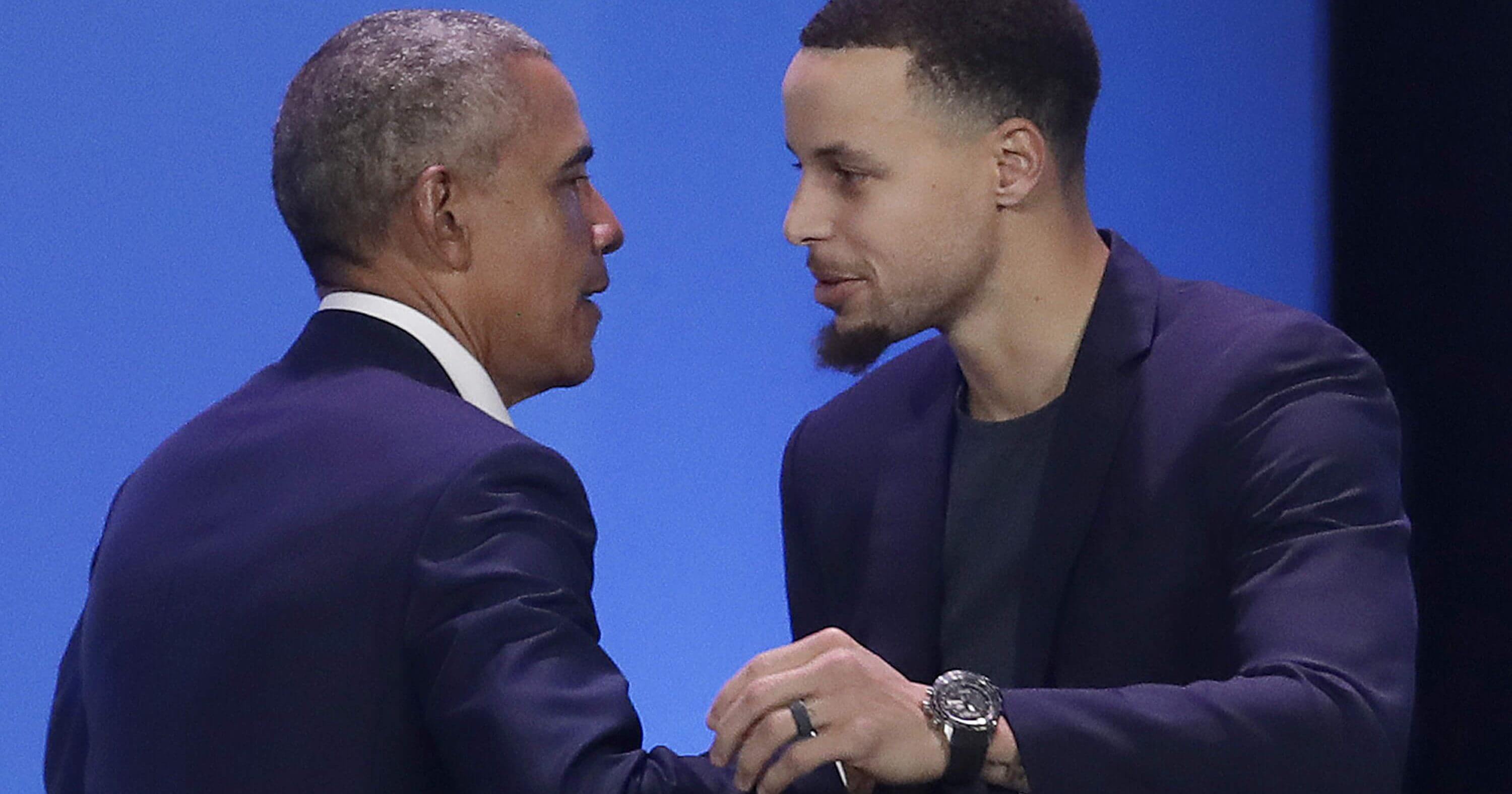 Former President Barack Obama, left, hugs Golden State Warriors basketball player Stephen Curry after speaking at the My Brother's Keeper Alliance Summit in Oakland, California, on Tuesday.
