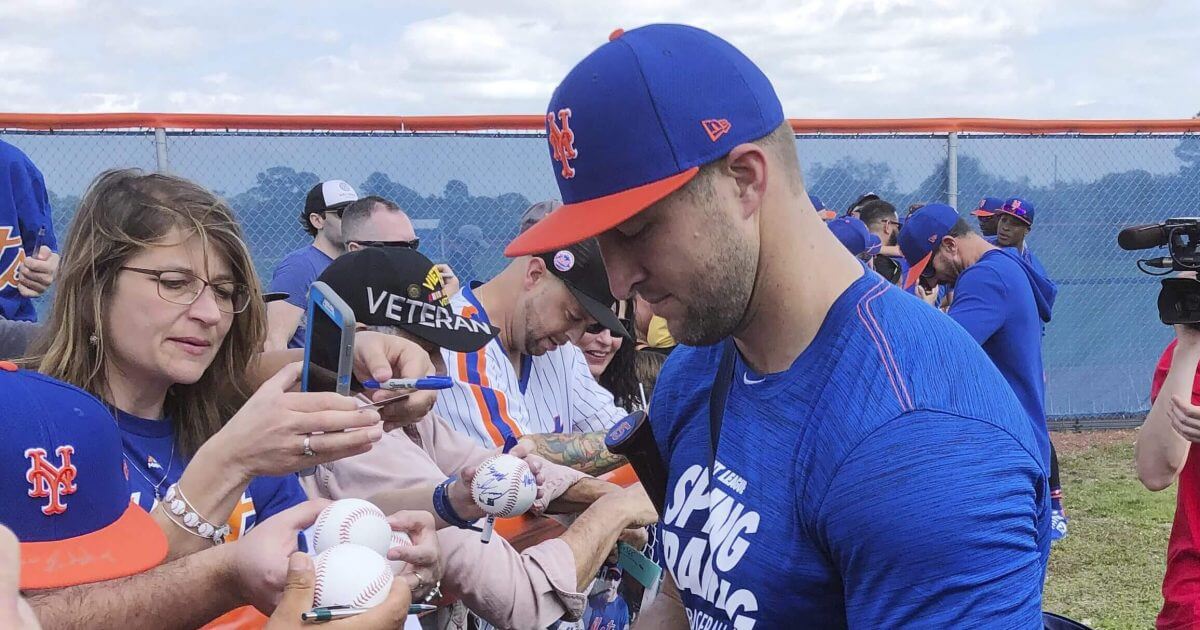 New York Mets prospect Tim Tebow signs autographs at spring training baseball practice on Saturday in Port St. Lucie, Florida.