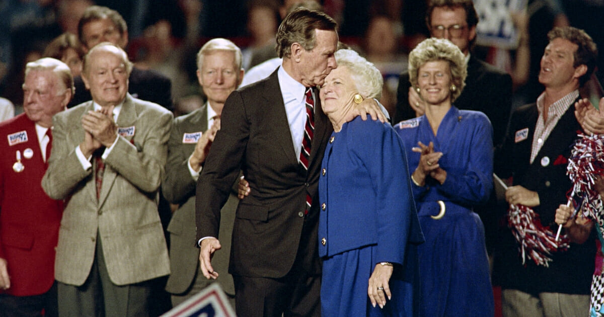 US President George Bush kisses his wife Barbara at the end of a rally held at the Astro Arena on November 2, 1992 on the eve of the 1992 presidential election.