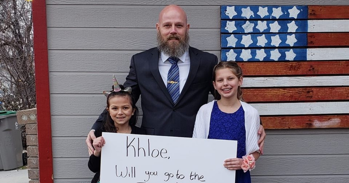 Man poses with two young girls before daddy-daughter dance.