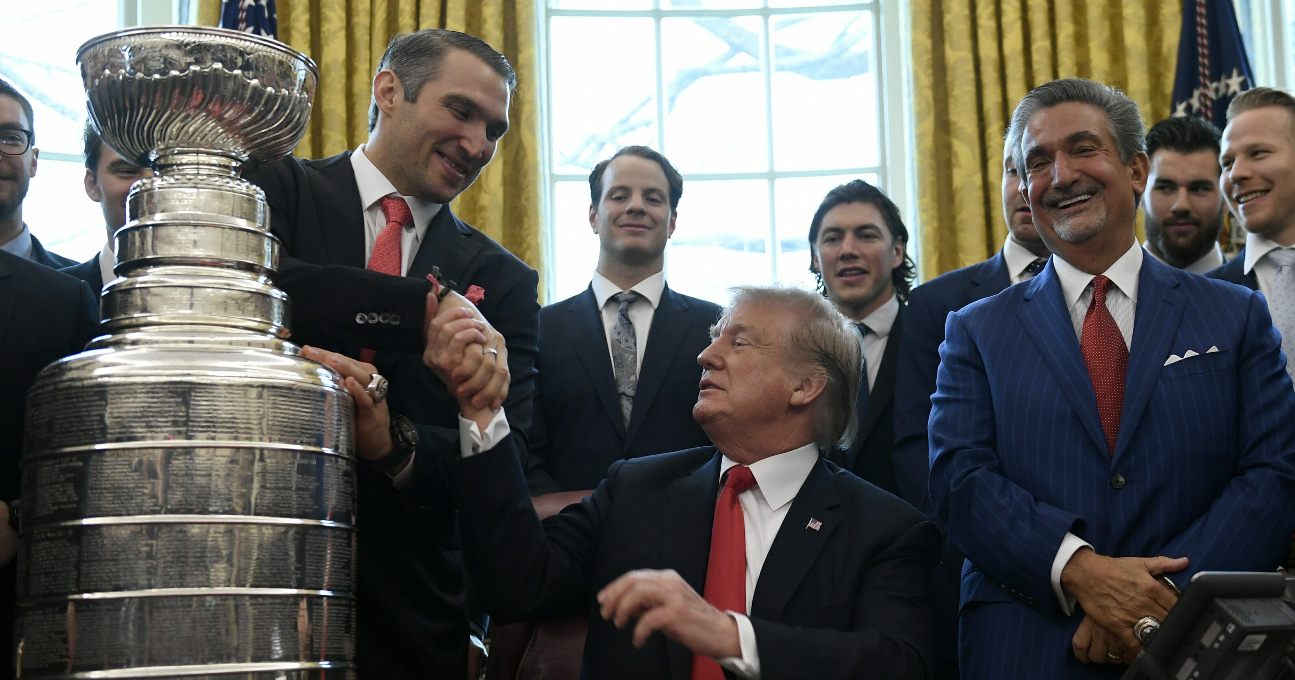 President Donald Trump, center, shakes hands with Alex Ovechkin, second from left, the captain and MVP of the 2018 Stanley Cup Champion Washington Capitals hockey team, during a visit to the Oval Office of the White House in Washington, Monday, March 25, 2019.