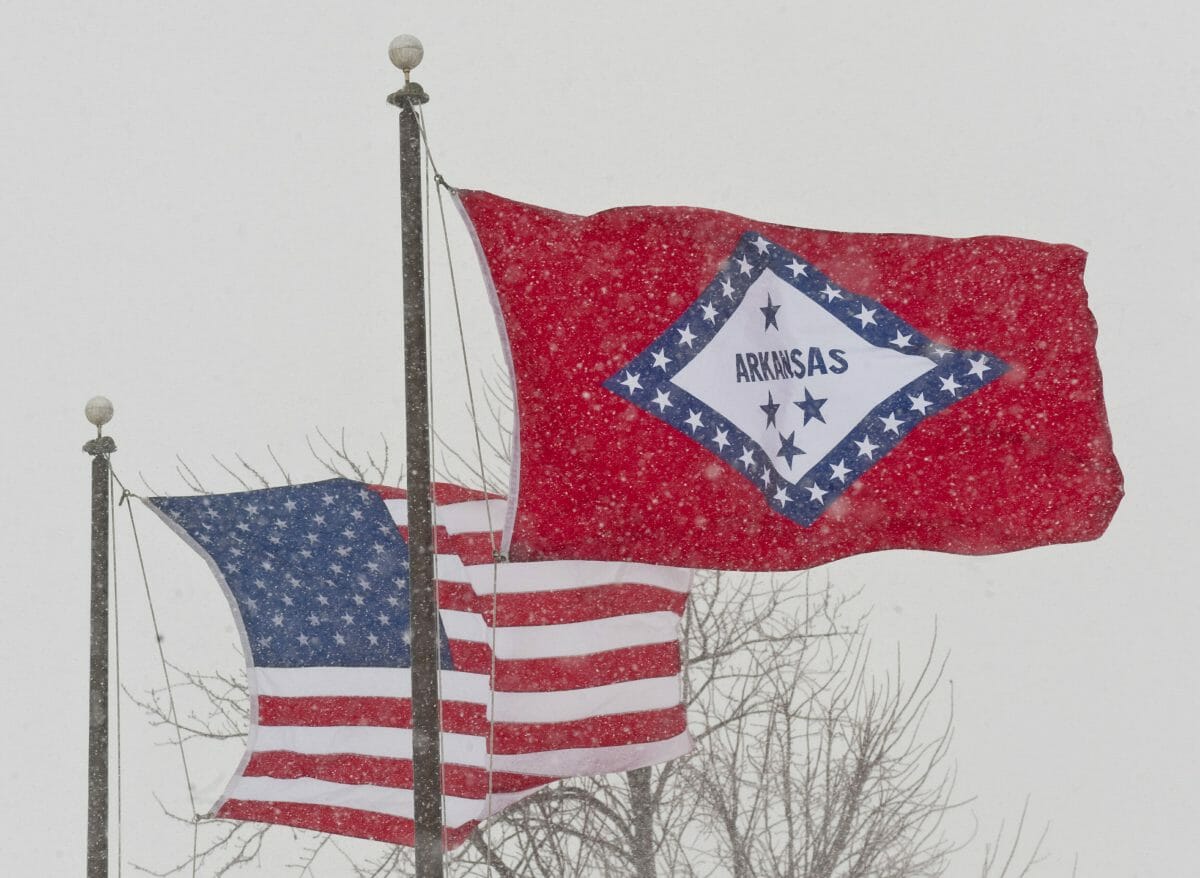 An American and Arkansas flag blow in the wind in Fayetteville, Arkansas.
