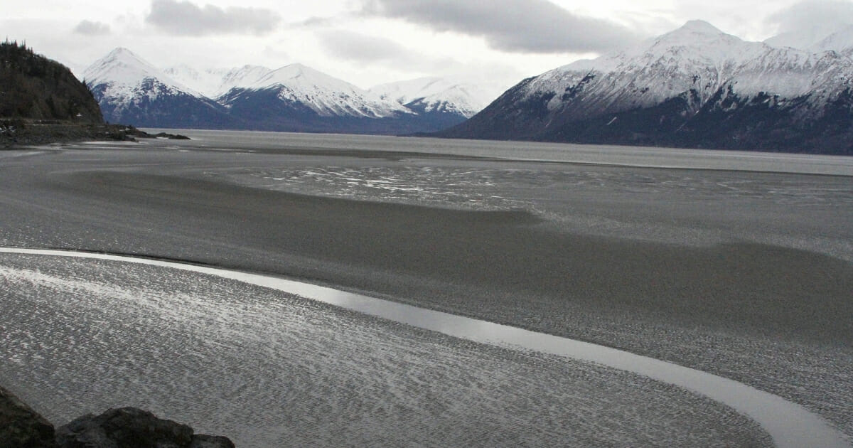 A ribbon of water cuts through mud flats of Cook Inlet off the shore of Anchorage, Alaska, on March 7, 2016.