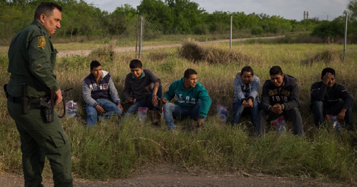 A Border Patrol agent guards a group of illegal immigrants.