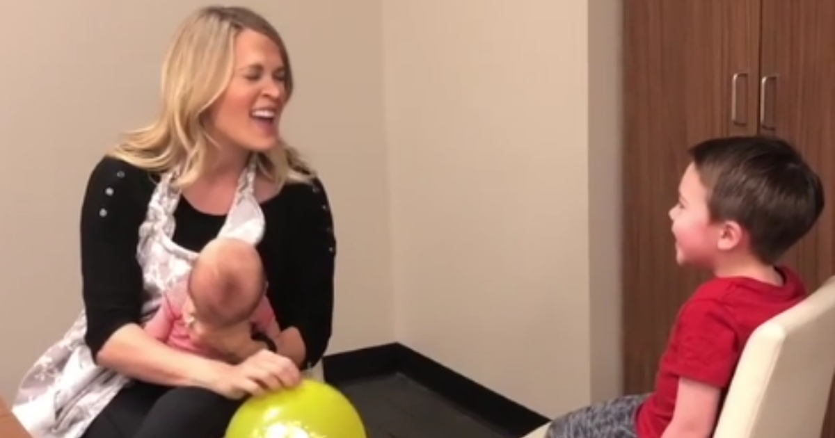 Carrie Underwood sings to her son while holding her baby.