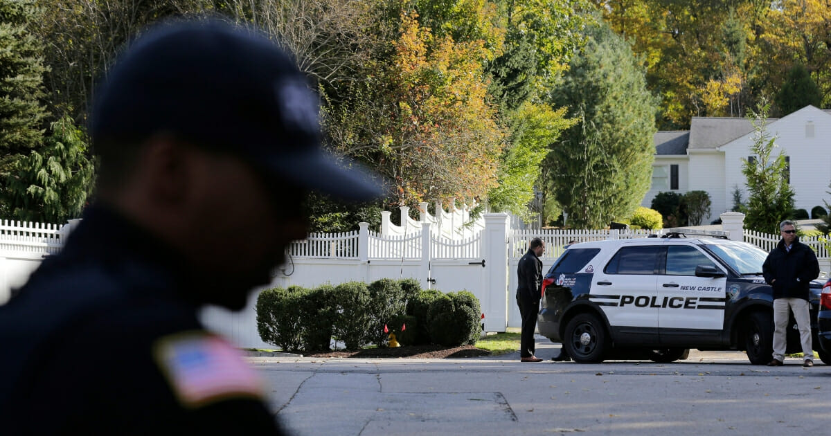 Police officers stand in front of property owned by former Secretary of State Hillary Clinton and former President Bill Clinton in Chappaqua, New York, on Oct. 24, 2018, after an explosive device was discovered.