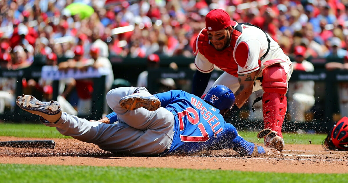 Addison Russell of the Chicago Cubs scores a run against Yadier Molina of the St. Louis Cardinals during a May 5, 2018, game at Busch Stadium.