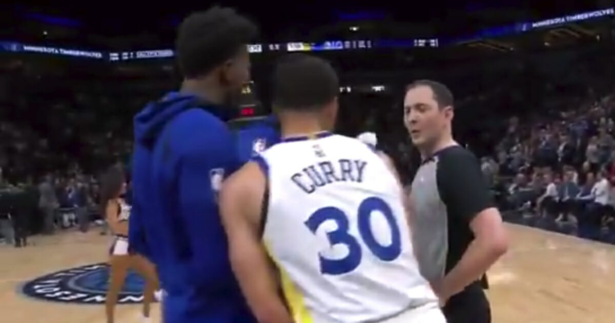 DeMarcus Cousins gets between Steph Curry and the referee during the Warriors' game against the Timberwolves.