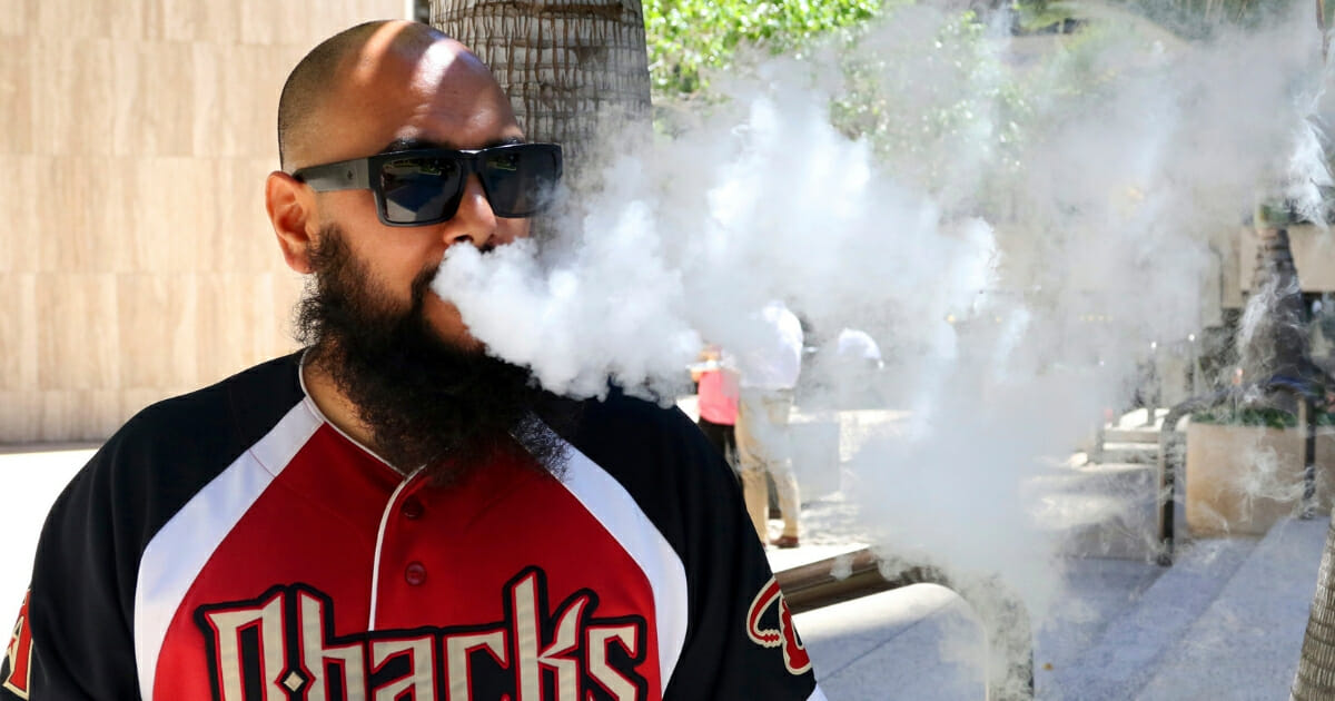 Trevor Husseini exhales a vape cloud in Honolulu on Thursday, March 28, 2019. Hawaii lawmakers are considering outlawing flavored tobacco and electronic cigarette liquids.