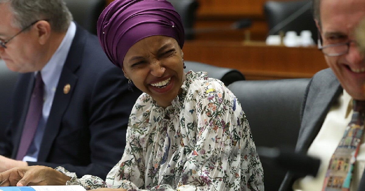 REp. Ilhan Omar laughs in Congress on Tuesday.