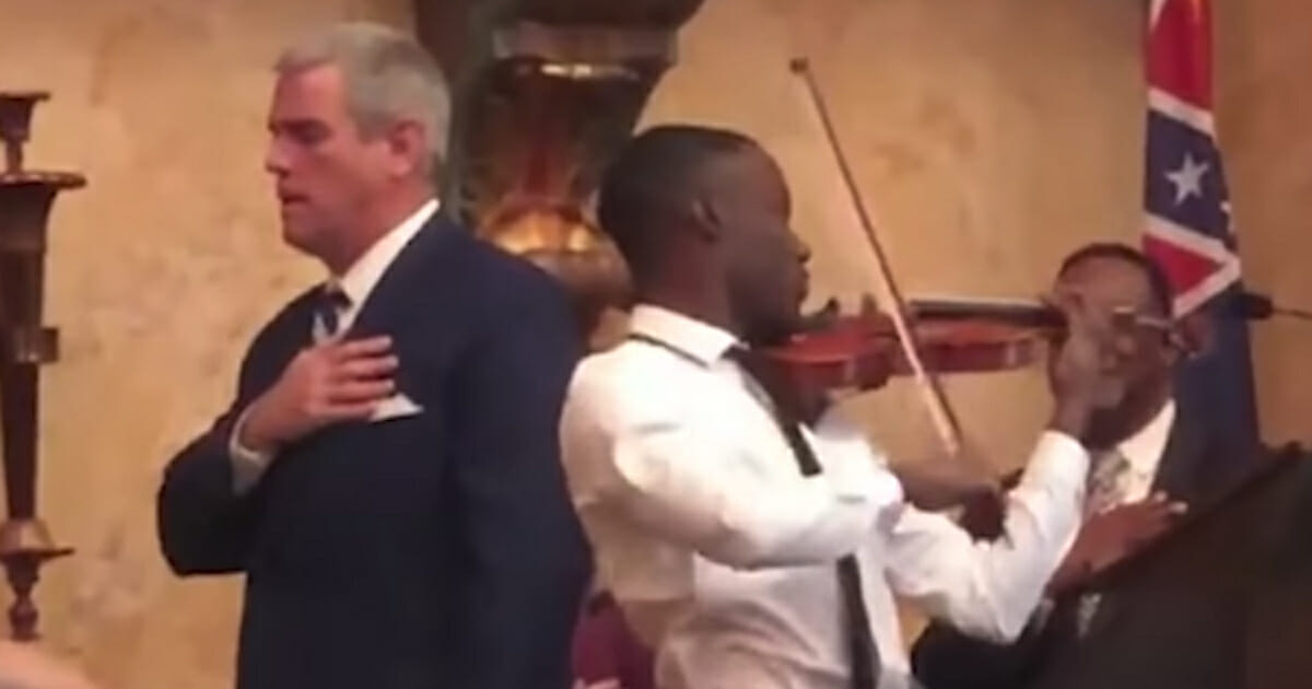 Man plays the national anthem on the violin for a state House of Representatives.