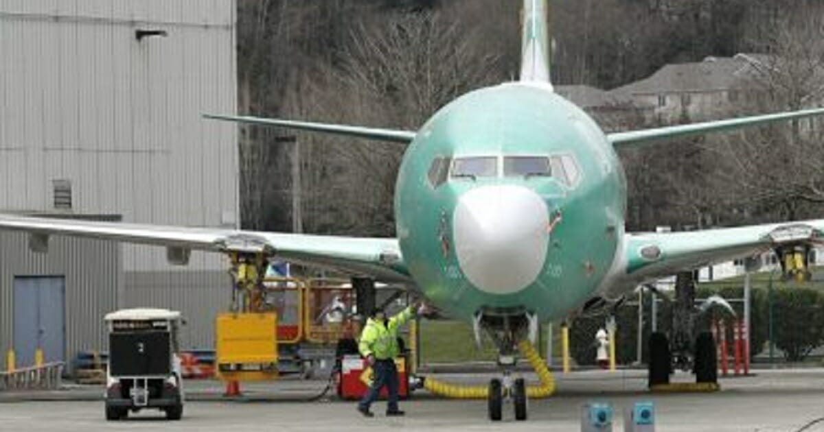 A worker stands near a Boeing 737 MAX 8 airplane parked at Boeing Co.'s Renton Assembly Plant on Monday in Renton, Washington.