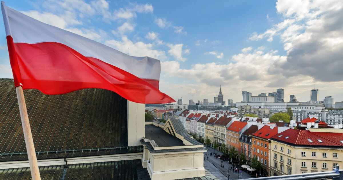 Poland flag with the city of Warsaw in the background.