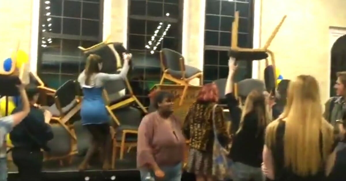 Students at Beloit College pile up chairs to try to prevent Blackwater founder Erik Prince from speaking on campus.