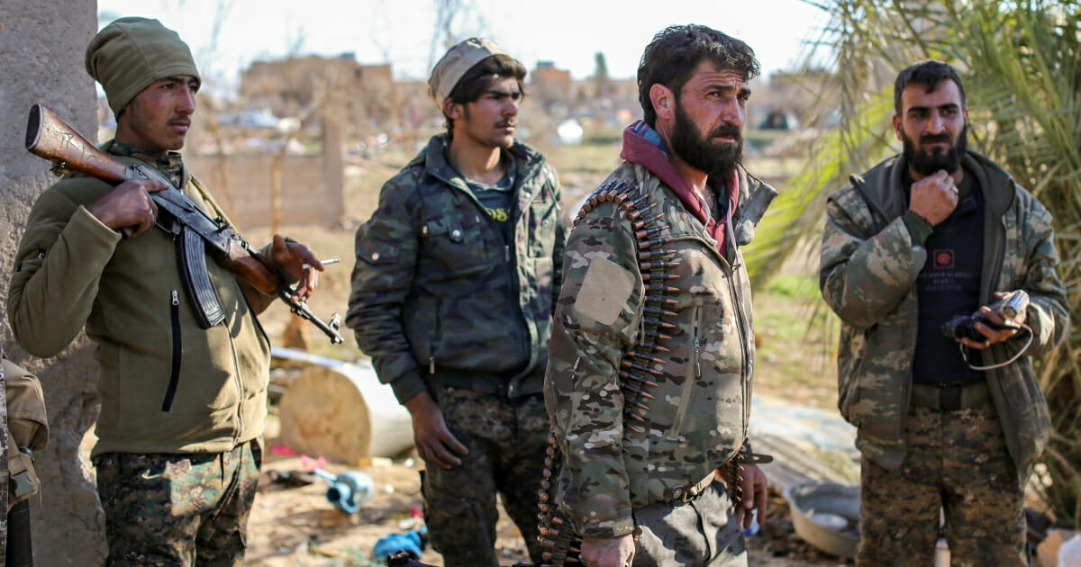 Fighters with the Syrian Democratic Forces check a makeshift camp for Islamic State group members and their families in the town of Baghouz in the eastern Syrian province of Deir Ezzor on March 9, 2019.