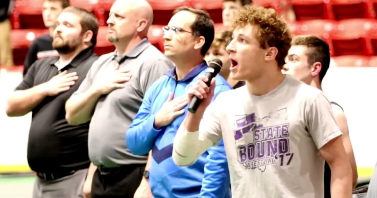 Isaac Bryant, a wrestler at Mechanicsburg High School in Ohio, sings the national anthem.