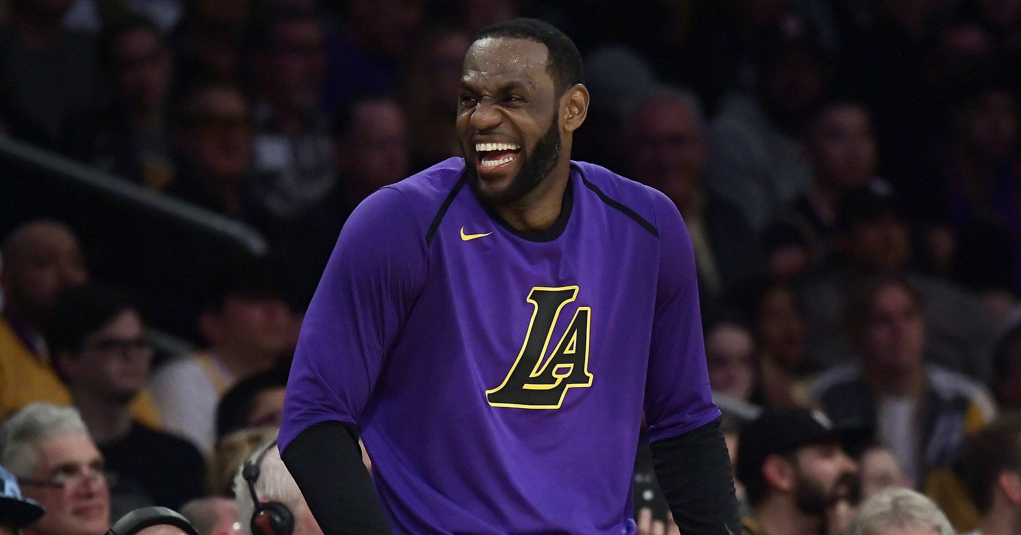 Los Angeles Lakers forward LeBron James laughs as he waits to check in to the team's NBA basketball game against the Charlotte Hornets during the second half Friday, March 29, 2019, in Los Angeles.