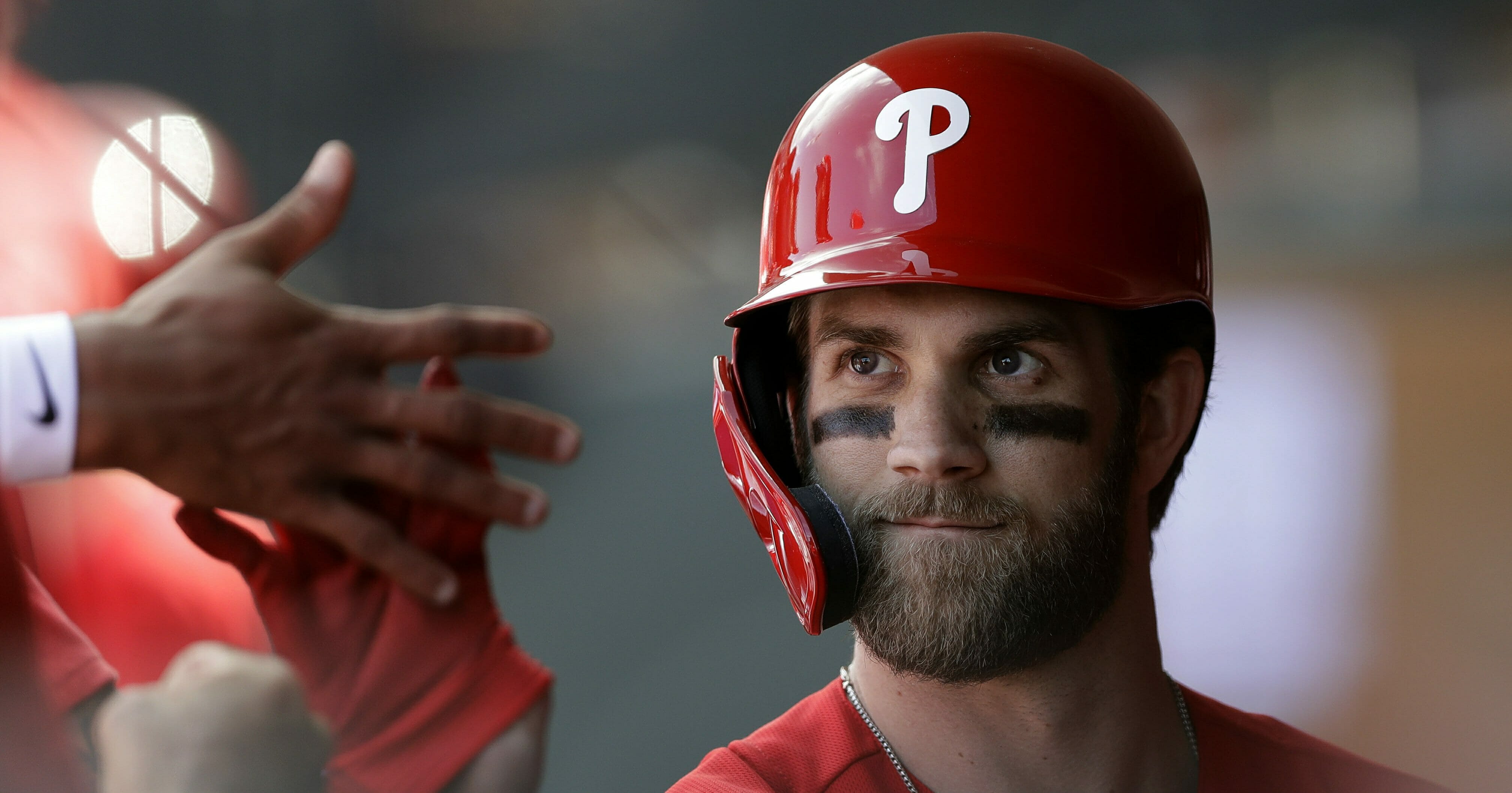 Philadelphia Phillies' Bryce Harper high-fives teammates after being taken out during the third inning of a spring training baseball game against the Toronto Blue Jays, Saturday, March 9, 2019, in Clearwater, Fla.