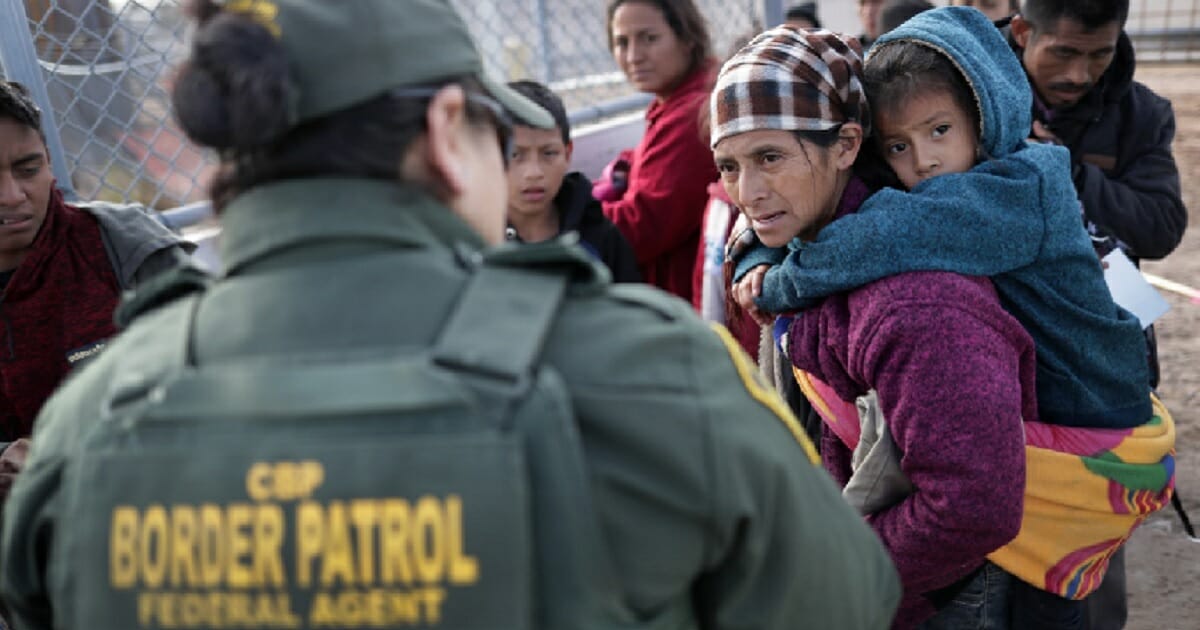 A Border Patrol agent takes Central American immigrants into custody after they crossed the border from Mexico on Feb. 1.