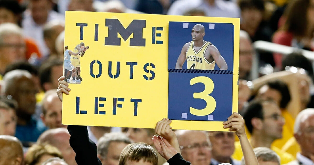 A fan holds up a sign which reads as a TImeout counter in reference to former Michigan Wolverines player Chris Webber as Michigan plays against the Syracuse Orange at the Georgia Dome on April 6, 2013 in Atlanta