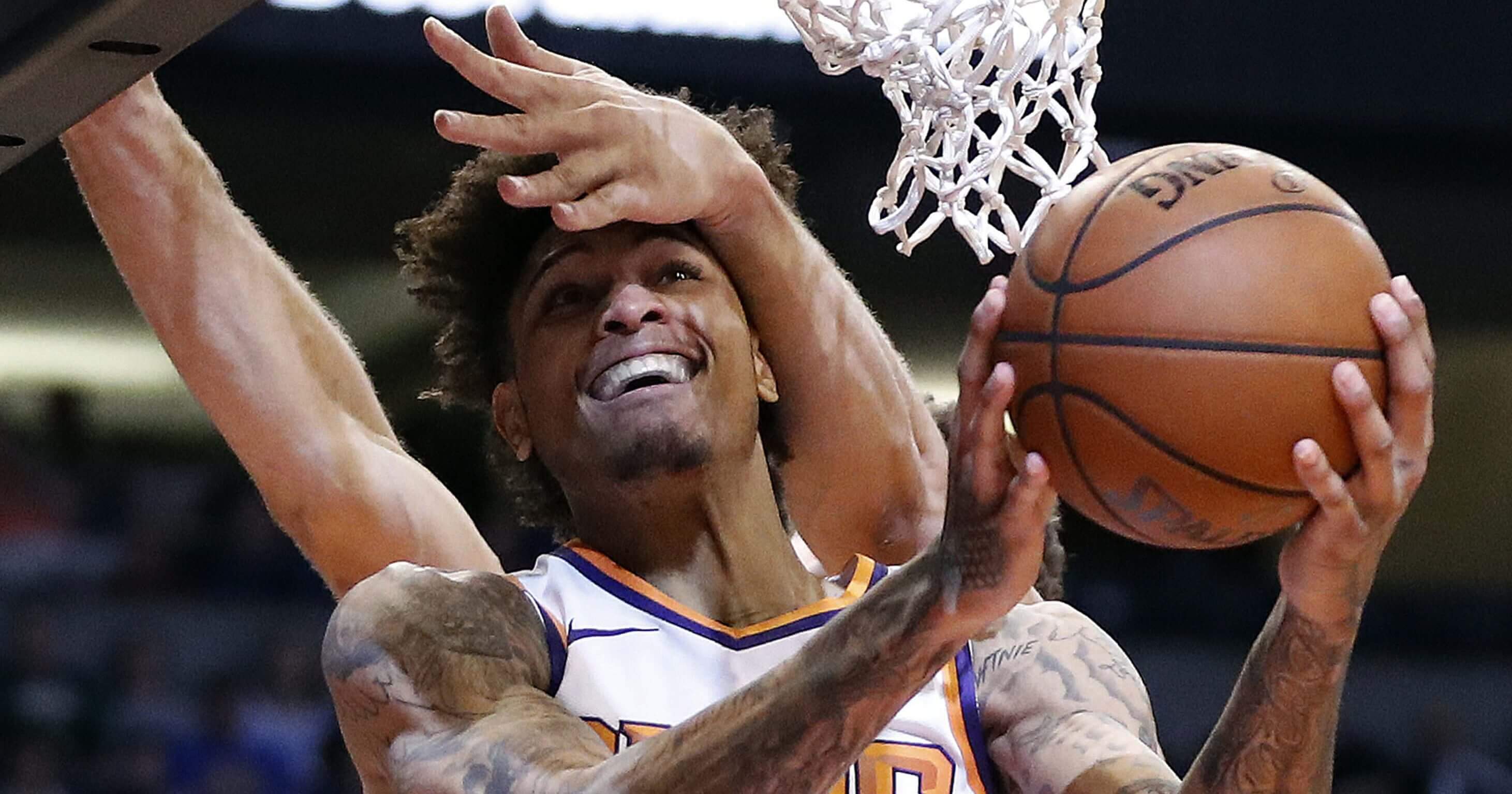 Phoenix Suns forward Kelly Oubre Jr. is fouled by Milwaukee Bucks center Brook Lopez during the second half of an NBA basketball game, Monday, March 4, 2019, in Phoenix