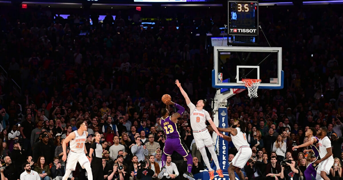 LeBron James of the Los Angeles Lakers attempts a basket but is blocked by Mario Hezonja of the New York Knicks in the last seconds of the game at Madison Square Garden on March 17, 2019 in New York City.