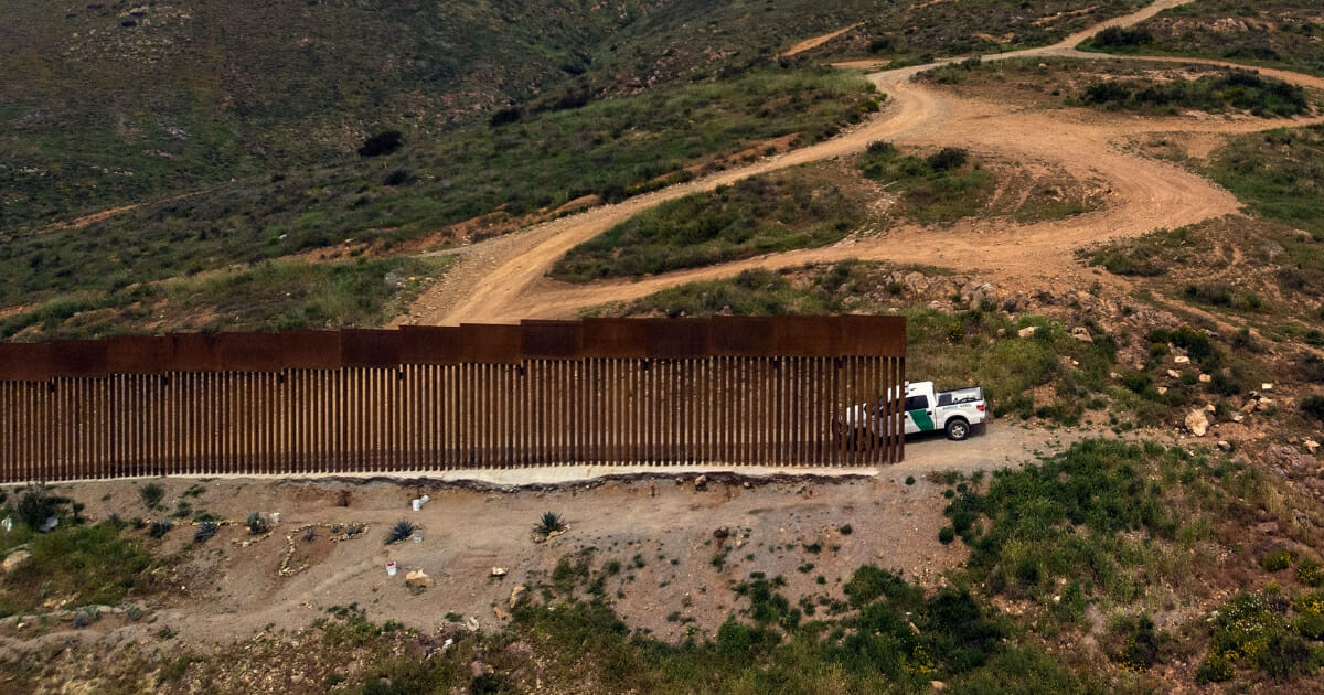 Border Patrol unit remains next to a section of the U.S-.Mexico border fence.
