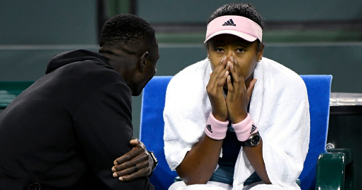 Naomi Osaka of Japan talks with his new coach Jermaine Jenkins during a match against Kristina Mladenovic of France during the BNP Paribas Open on March 9, 2019 in Indian Wells, California.