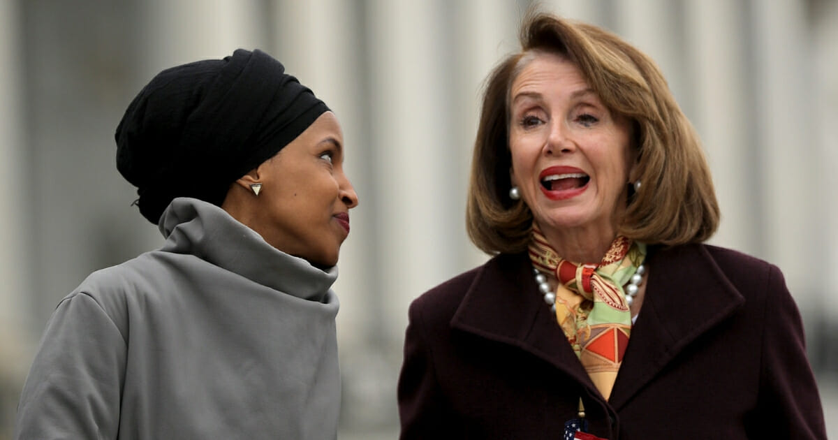 Rep. Ilhan Omar talks with Speaker of the House Nancy Pelosi during a rally with fellow Democrats before voting on H.R. 1.