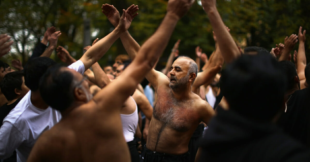 Shiite Muslim devotees beat their chests as they take part in a ritual self-flagellation.
