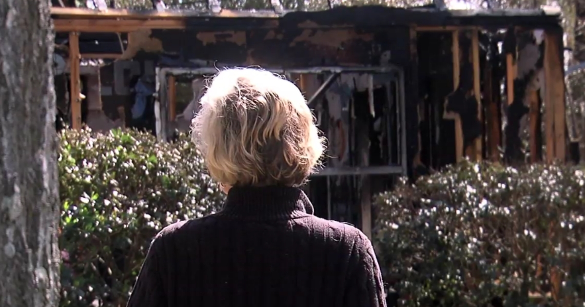 A woman looks at her destroyed home.