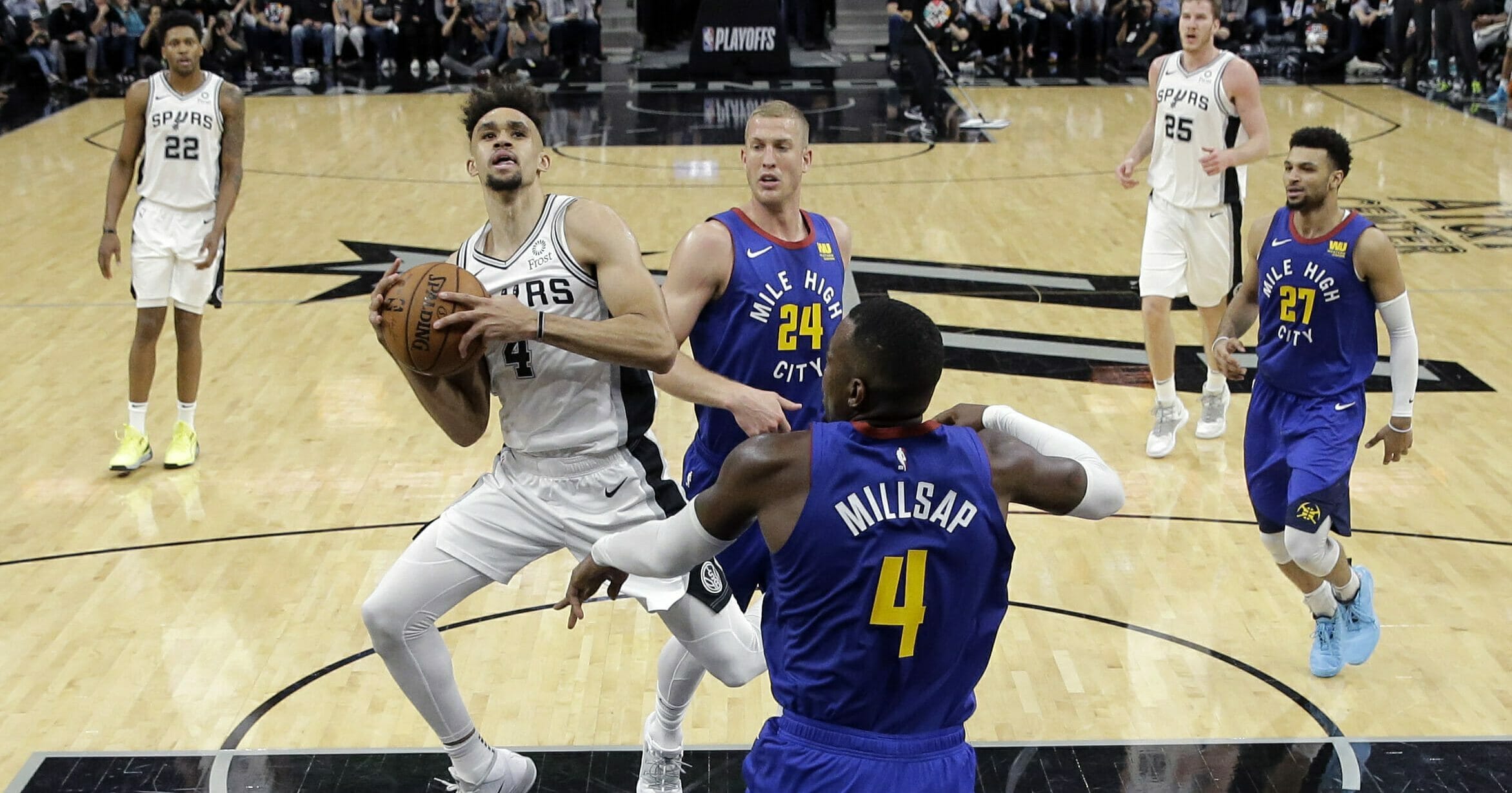 San Antonio Spurs guard Derrick White (4) drives to the basket against Denver Nuggets forward Paul Millsap (4) during Game 3 of their playoff series on April 18, 2019.