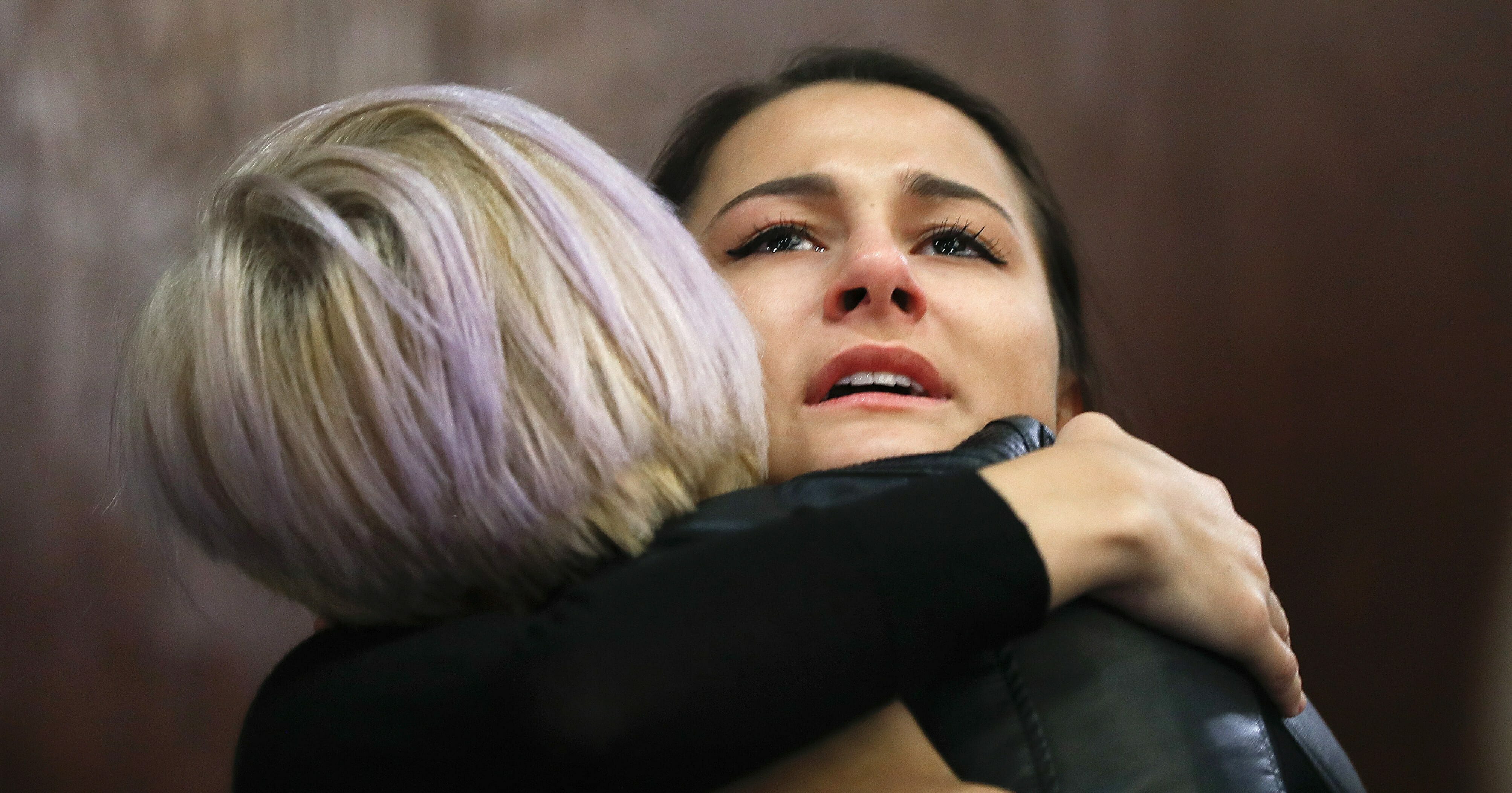 Bailey Kowalski hugs a friend after a news conference in East Lansing, Mich., Thursday, April 11, 2019.