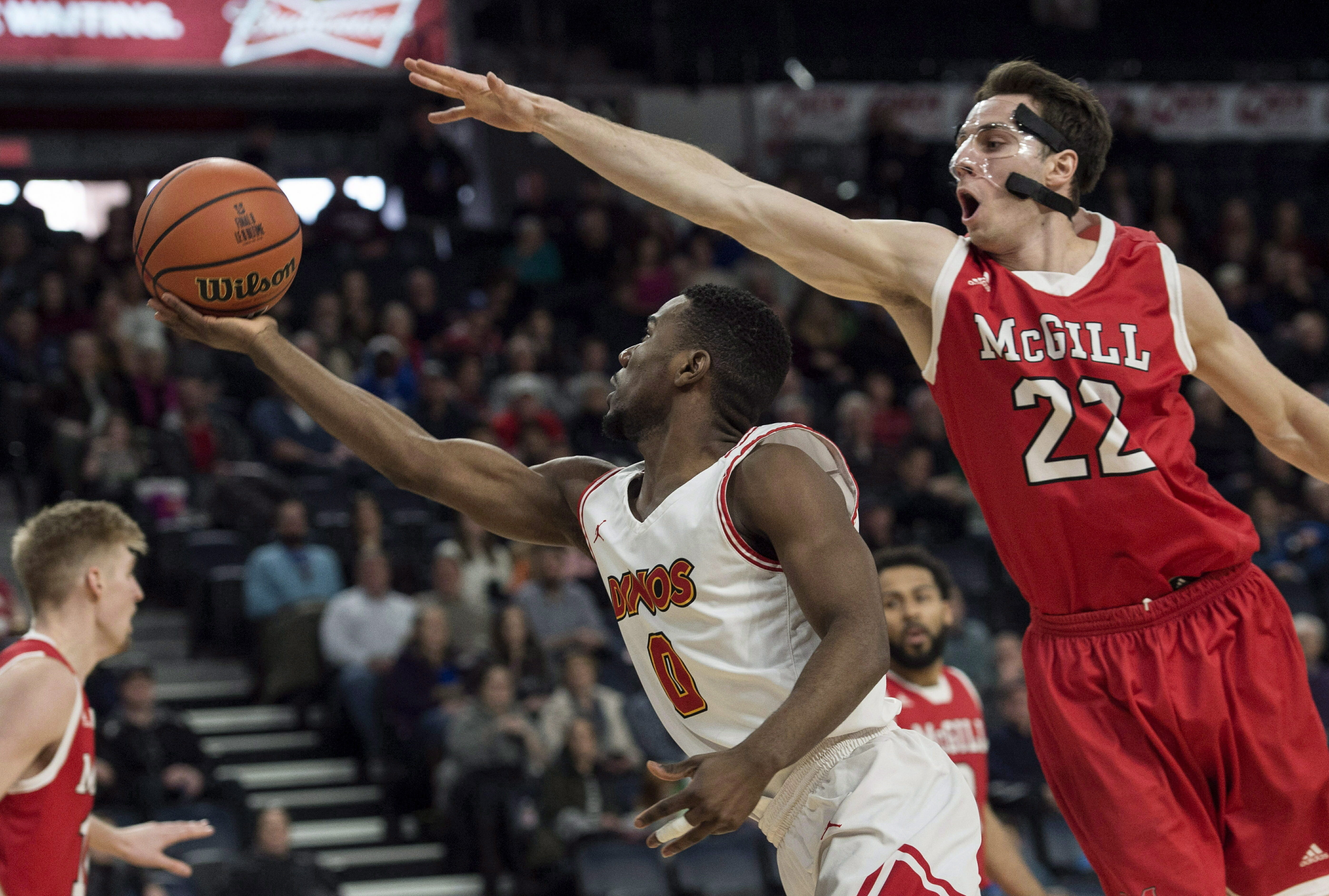 In this March 10, 2018 photo, Calgary's David Kapinga, left, shoots as McGill's Francois Bourque defends during the first half of in the semifinals of the men's basketball national championship in Halifax, Nova Scotia.