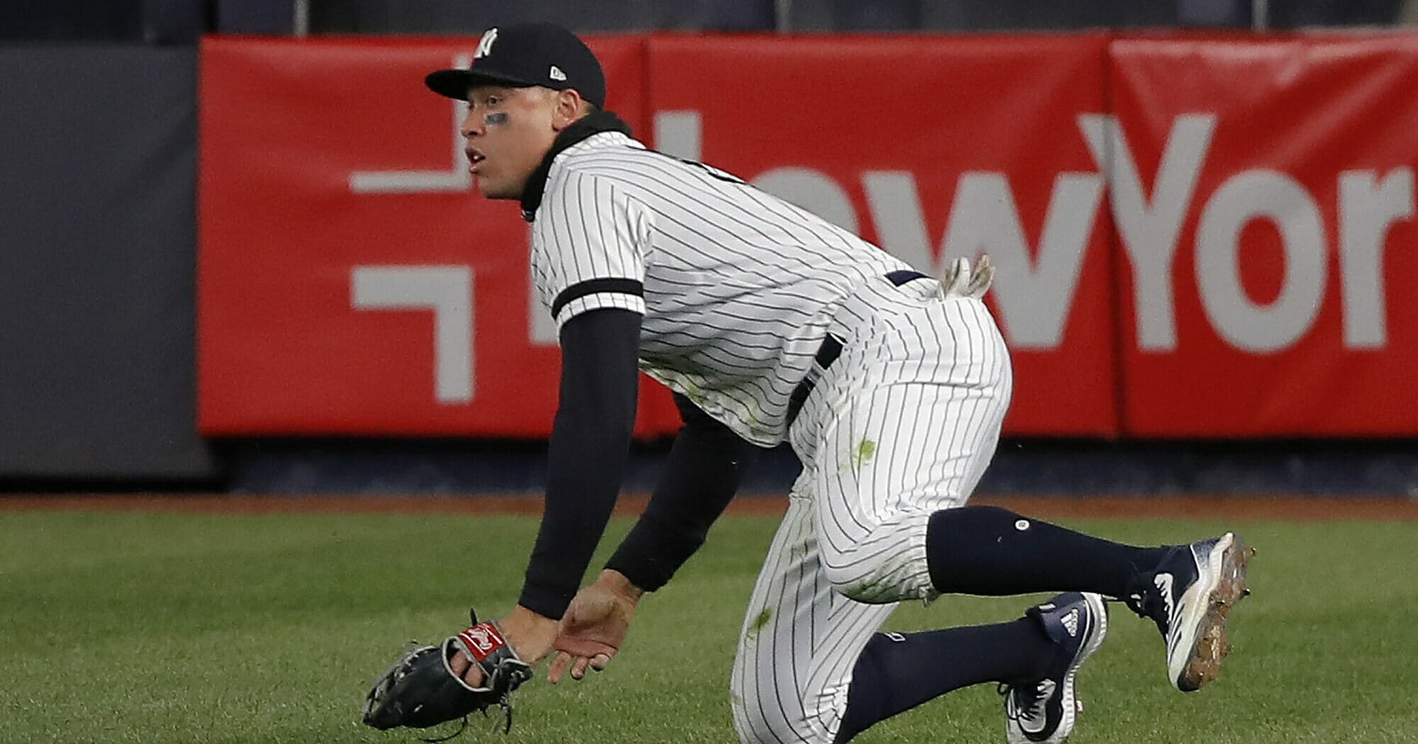 New York Yankees right fielder Aaron Judge comes up off the grass after catching a line drive by Detroit Tigers' Niko Goodrum with two men on base during the eighth inning of a baseball game, Monday, April 1, 2019, in New York.