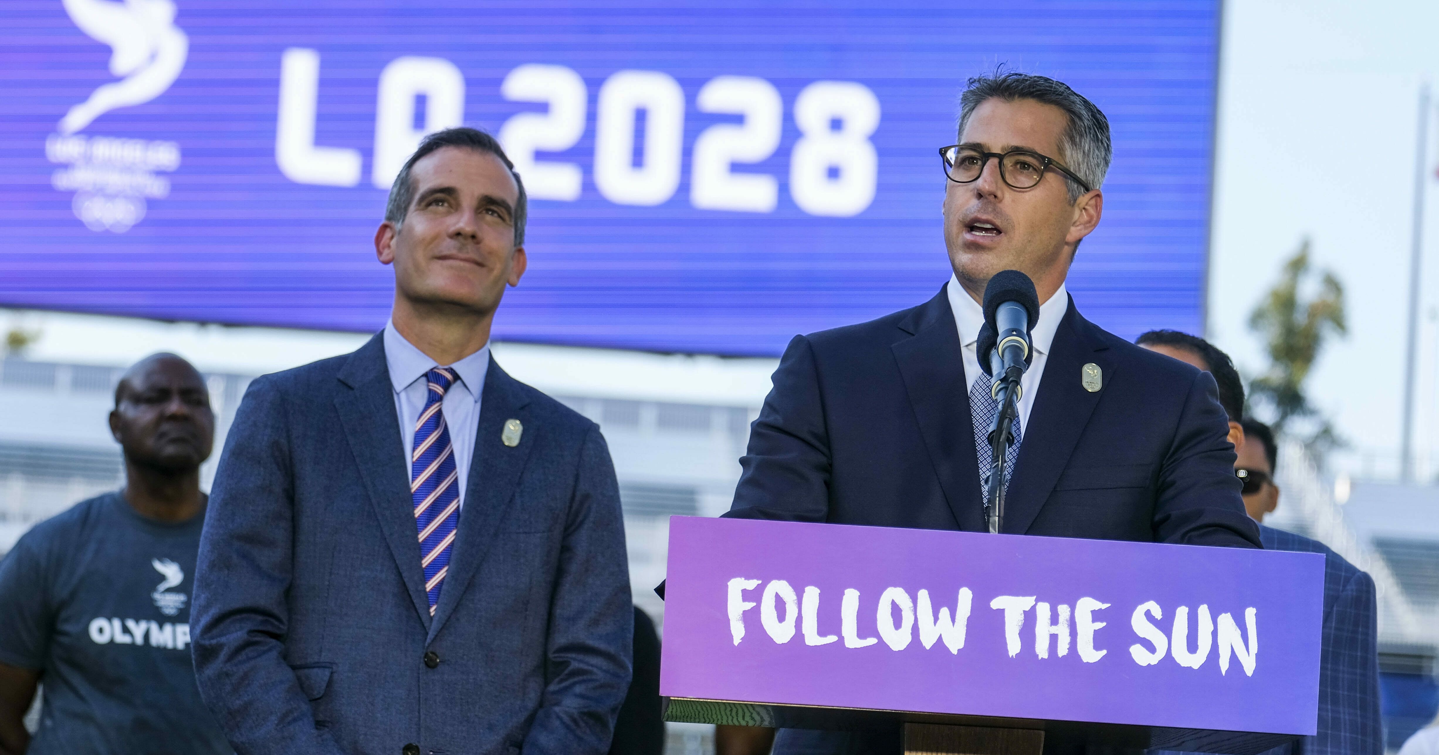 Los Angeles Mayor Eric Garcetti, left, listens as Los Angeles Olympic Committee leader Casey Wasserman speaks during a July 31, 2017, news conference to announce the city is hosting the 2028 Summer Games.