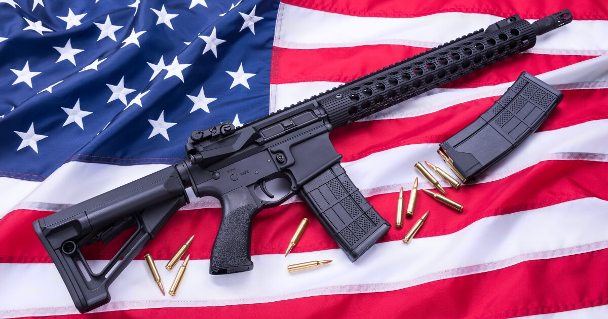 A high capacity magazine next to an AR-15 on an American flag.