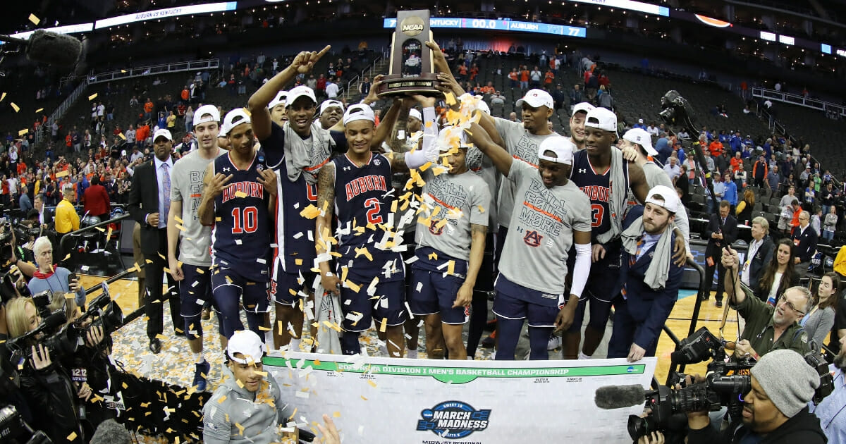The Auburn Tigers celebrate with the trophy after defeating the Kentucky Wildcats 77-71 in overtime during the NCAA Tournament Midwest Regional at Sprint Center in Kansas City on March 31, 2019.