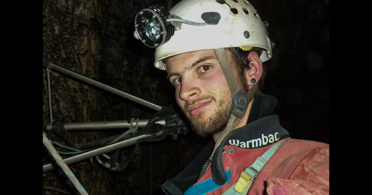 Josh Bratchley in a cave with his gear.
