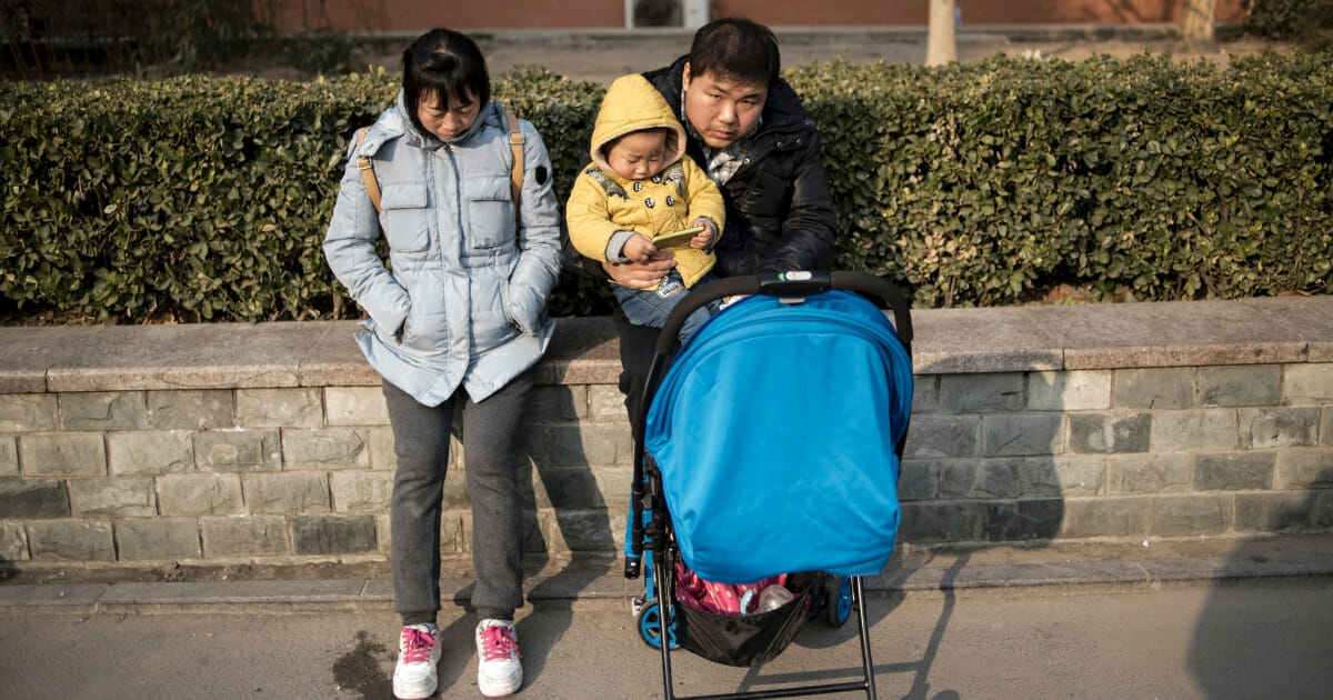 A couple and their child wait in the street of Beijing.