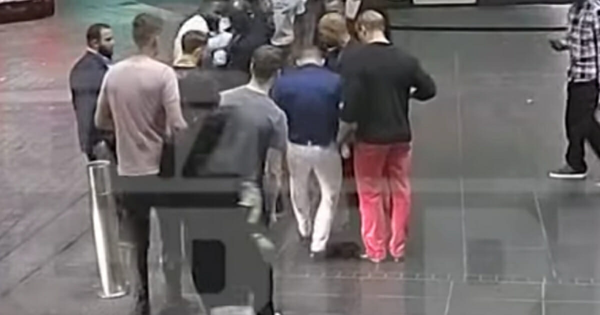 Conor McGregor, center in dark-blue shirt, smashes a cellphone.