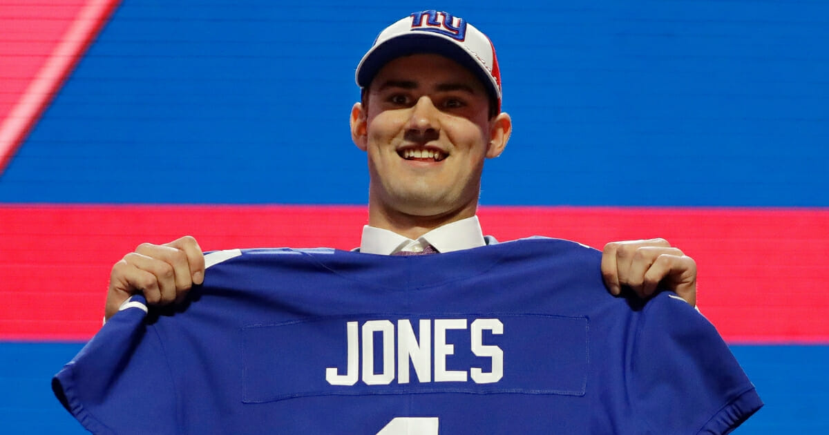 Duke quarterback Daniel Jones poses with his new jersey after the New York Giants selected him in the first round of the NFL draft.