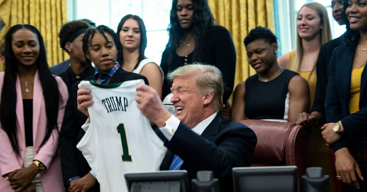 President Donald Trump holds up a jersey he was given by the Baylor women's basketball team.