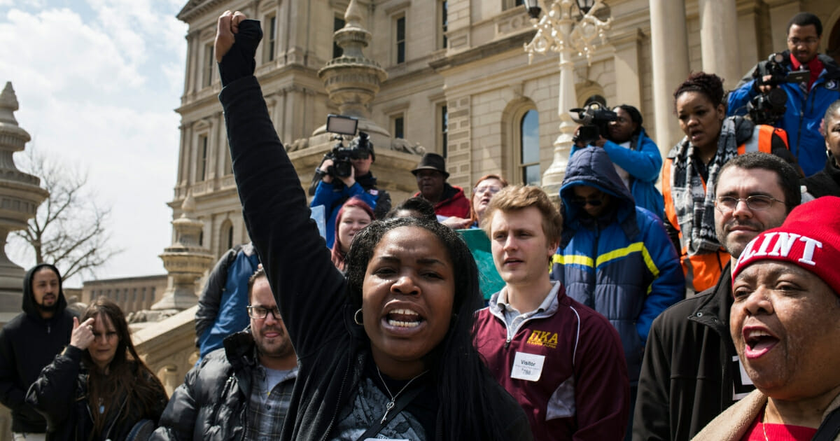 Ariana Hawk of Flint, Michigan, leads a chant during a protest on the steps of the Michigan State Capitol on April 11, 2018, in Lansing, Michigan.