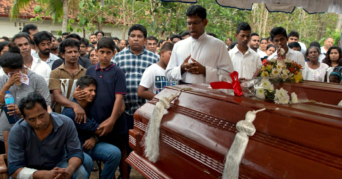Dimitra Silva, fourth left in blue, mourns the death of his brother, 13-year-old Anos Silva and his grandparents, who died during the Easter Sunday bomb blast at St. Sebastian Church in Negombo, Sri Lanka, on Monday, April 22, 2019.