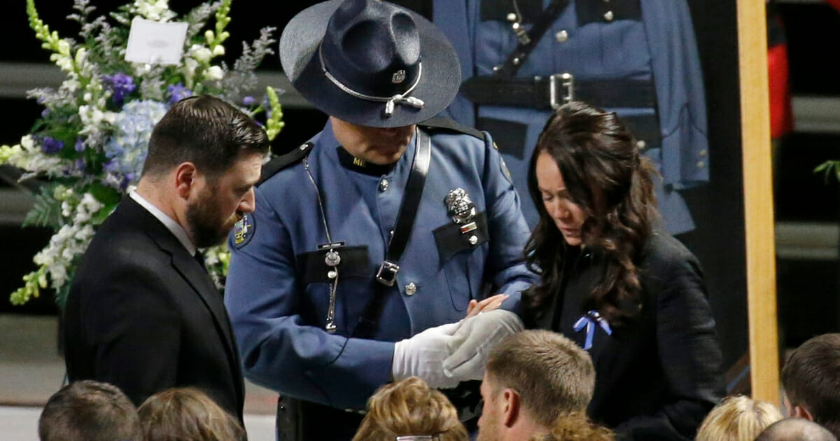 Hilary Campbell, the widow of Maine State Police detective Ben Campbell, takes her seat at the Cross Insurance Arena during a Law Enforcement Tribute, Tuesday, April 9, 2019, in Portland, Maine.