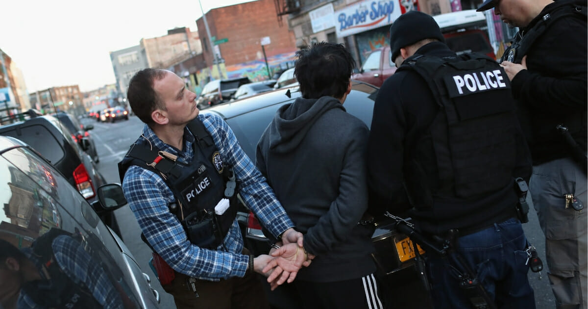ICE officers arresting a man.