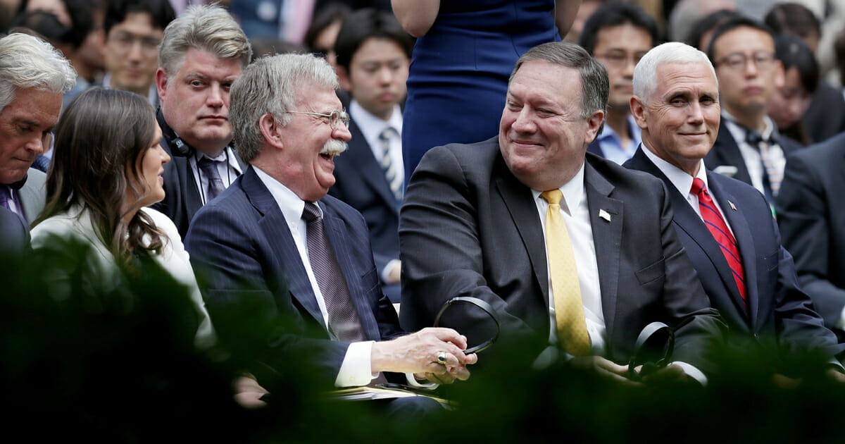 White House Press Secretary Sarah Huckabee Sanders, National Security Advisor John Bolton, U.S. Secretary of State Mike Pompeo and Vice President Mike Pence share a laugh before the start of a joint news conference with President Donald Trump and Japanese Prime Minister Shinzo Abe in the Rose Garden at the White House June 7, 2018, in Washington, D.C.