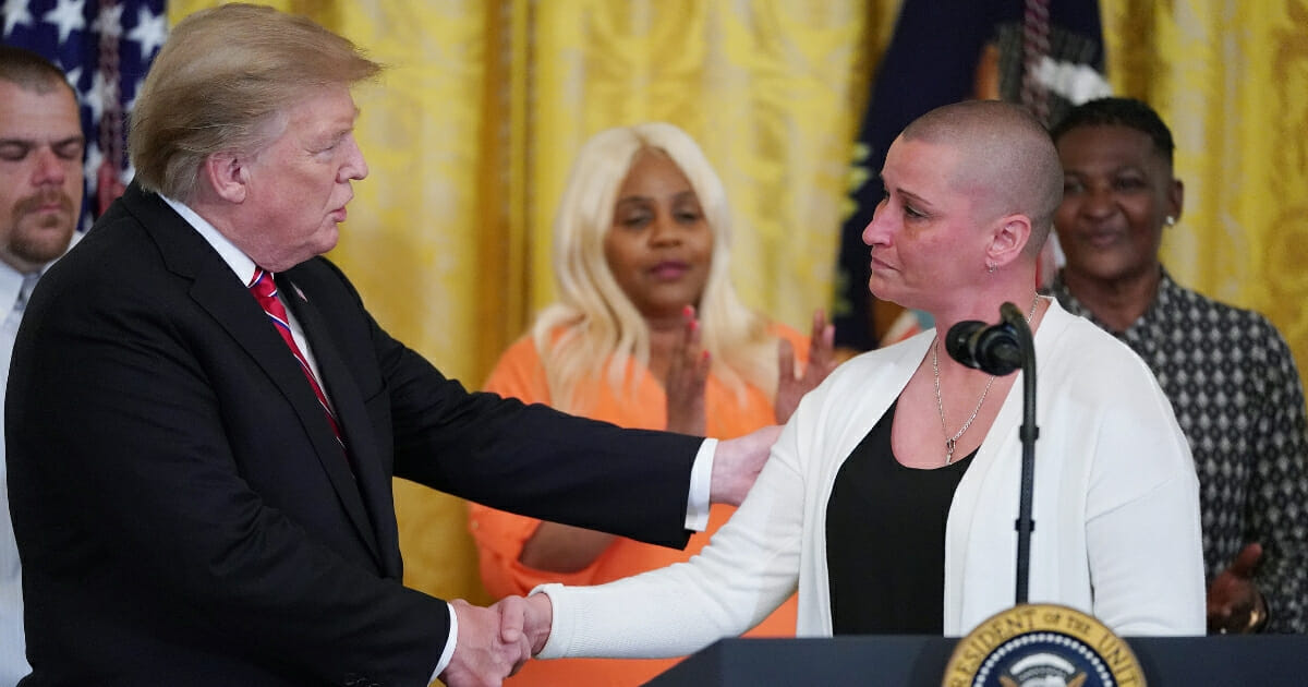 April Johnson, right, who was released from prison under the First Step Act, thanks President Donald Trump during a ceremony in the East Room of the White House on April 1, 2019.